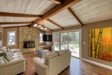 a living room with fireplace furniture and a large window