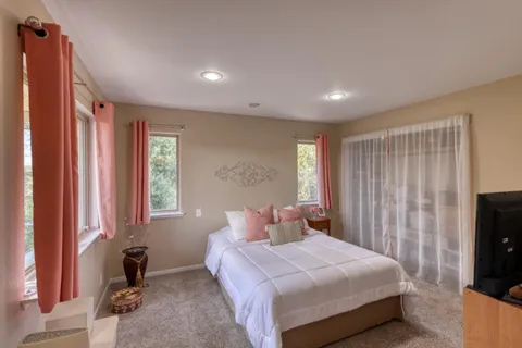 a bedroom with a bed and a flat tv screen on the dresser