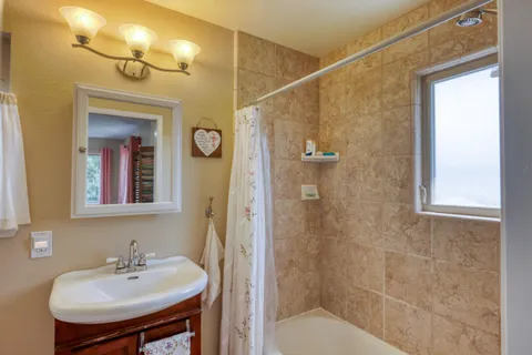a bathroom with a sink a mirror and a shower