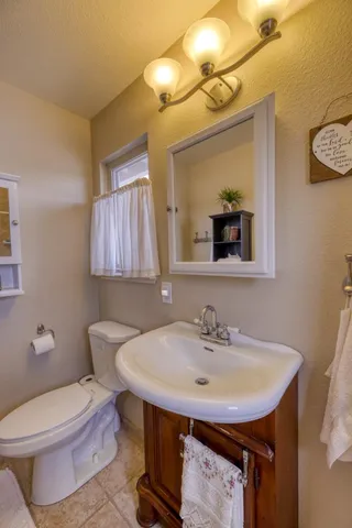 a bathroom with a sink a toilet and mirror