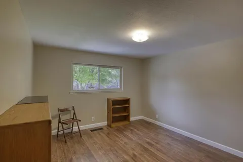 a view of a livingroom with wooden floor and a window