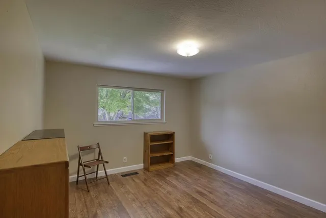 a view of a livingroom with wooden floor and a window