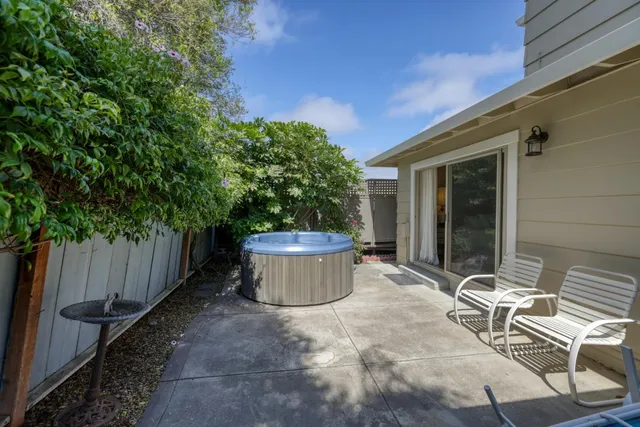 a view of a patio with table and chairs and wooden fence