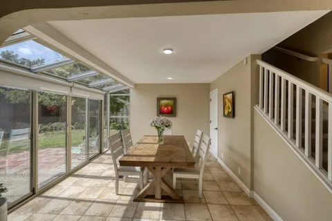 a workspace with furniture wooden floor and a floor to ceiling window