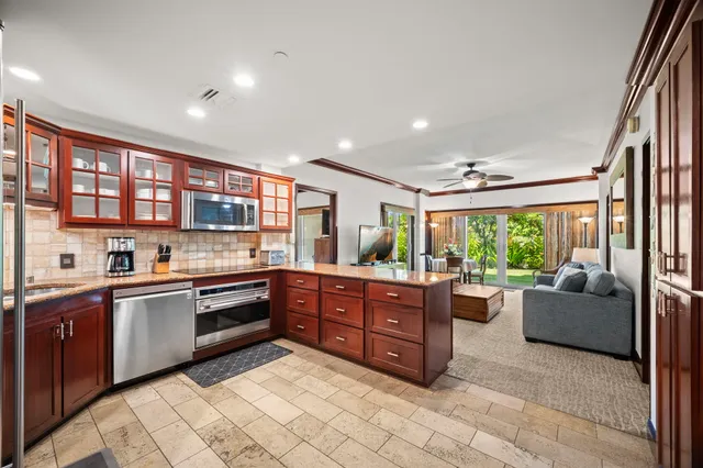 a kitchen with stainless steel appliances granite countertop sink window and cabinets