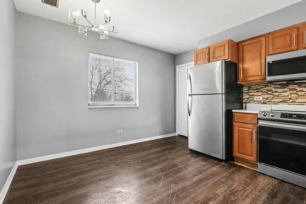 a kitchen with a refrigerator and a stove top oven