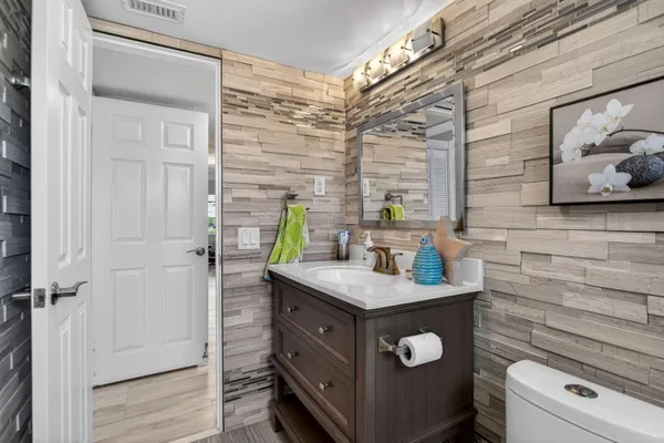 a bathroom with a granite countertop sink a toilet and with mirror