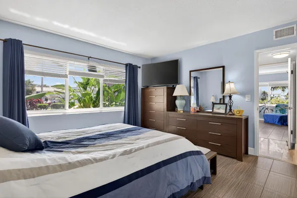 a bedroom with a bed and a large window