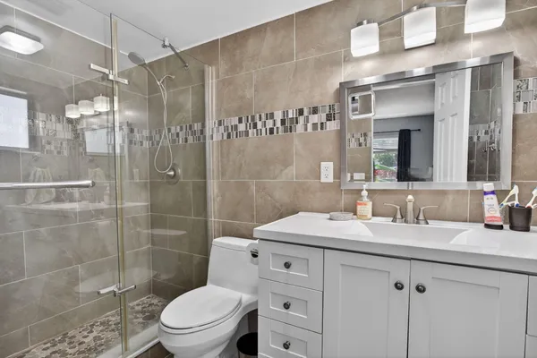 a bathroom with a sink a toilet and shower