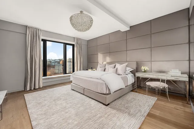 a bedroom with a large bed and a chandelier