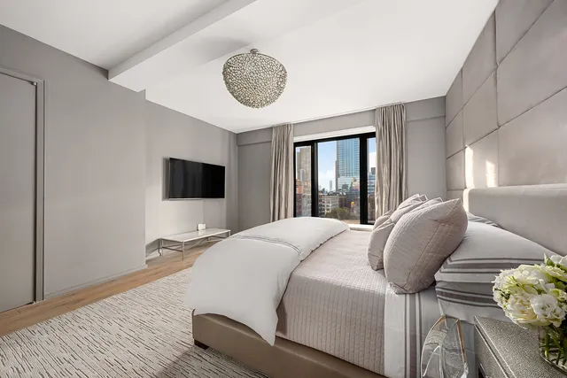 a bedroom with a bed and a chandelier