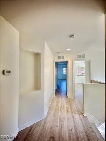 a view of a hallway with wooden floor and closet