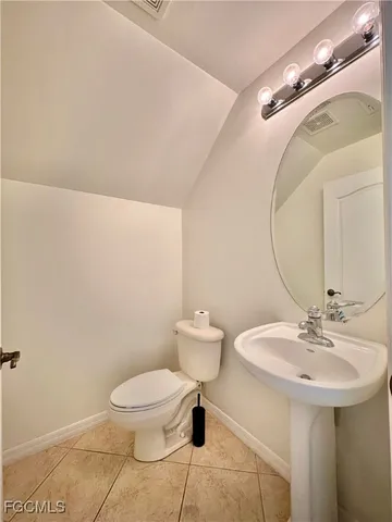 a bathroom with a sink mirror and toilet