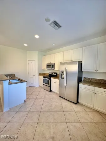 a kitchen with stainless steel appliances granite countertop a refrigerator and a stove top oven