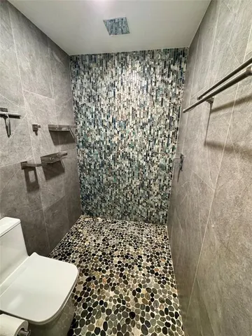 a bathroom with a toilet and a shower curtain