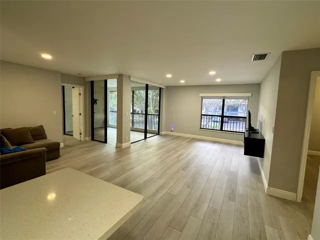 a furnished livingroom with a window and wooden floor