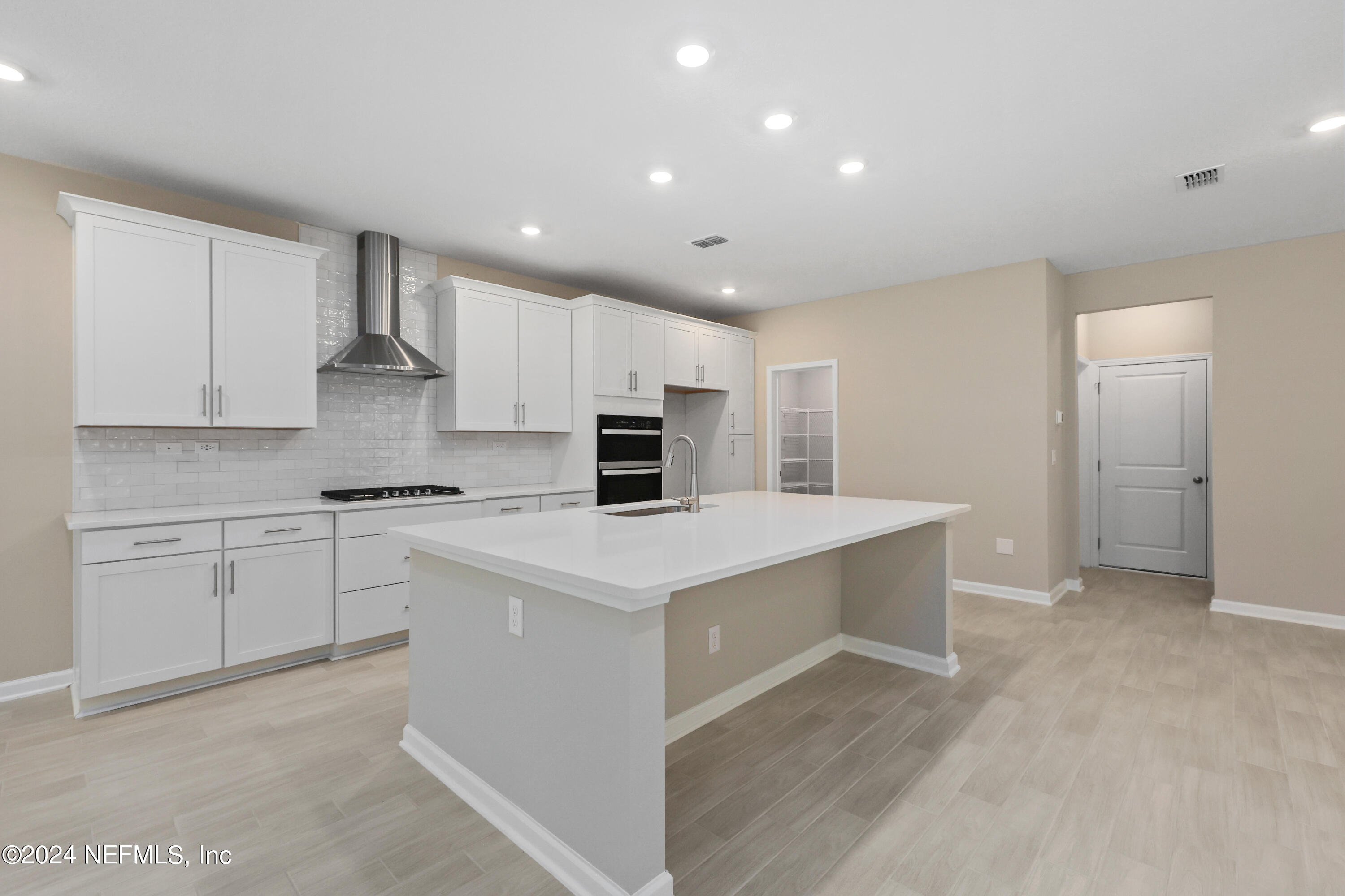 75605 Blackbird Drive Yulee, FL 32097 - Photo 12 of 46 a kitchen with a sink a stove a refrigerator and white cabinets