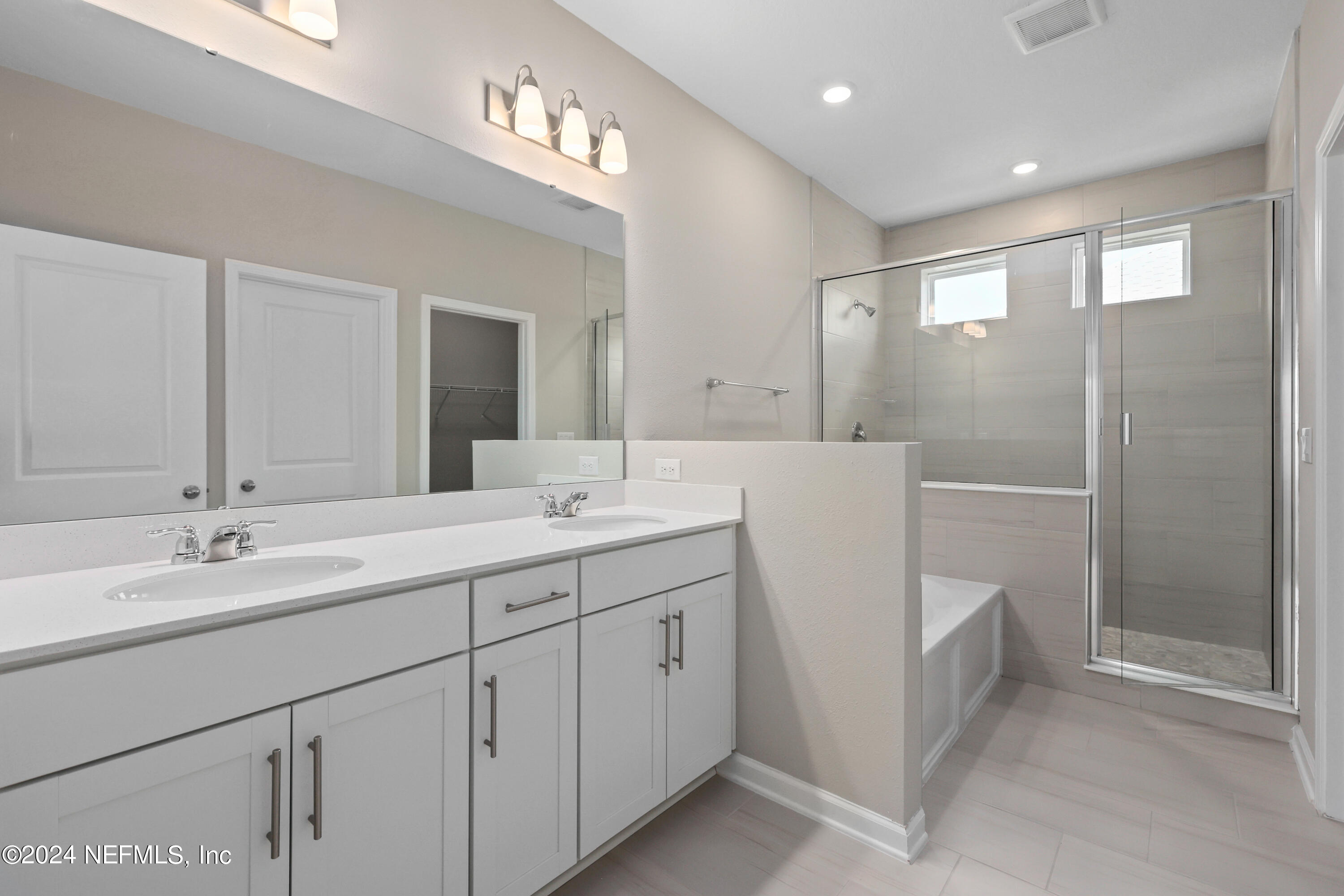 75605 Blackbird Drive Yulee, FL 32097 - Photo 4 of 46 a spacious bathroom with a double vanity sink a toilet and a mirror