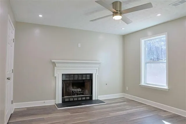 an empty room with a ceiling fan and a window