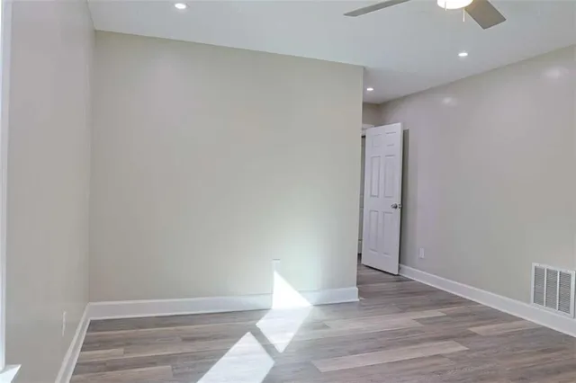 an empty room with a ceiling fan and a window