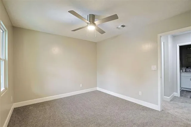 an empty room with a window and a fan