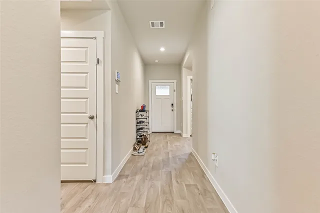 a view of a hallway with wooden floor