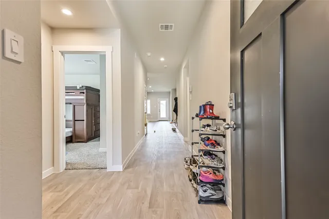 a view of a hallway with wooden floor and a living room