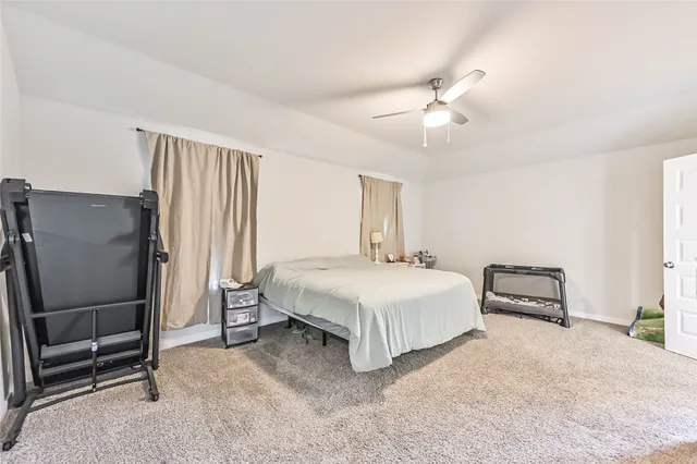 a spacious bedroom with a bed and a chandelier