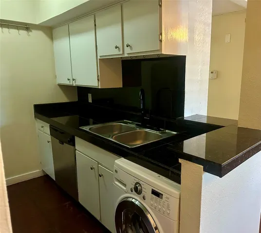 a kitchen with granite countertop a sink and a stove top oven