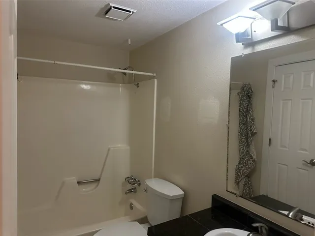 a bathroom with a sink mirror vanity and toilet