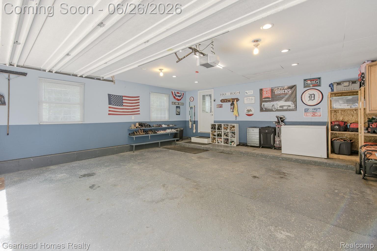 12364 Morrish Road Clio, MI 48420 - Photo 49 of 81 Spacious garage featuring light blue walls with a darker blue wainscoting, two windows, and a side entry door