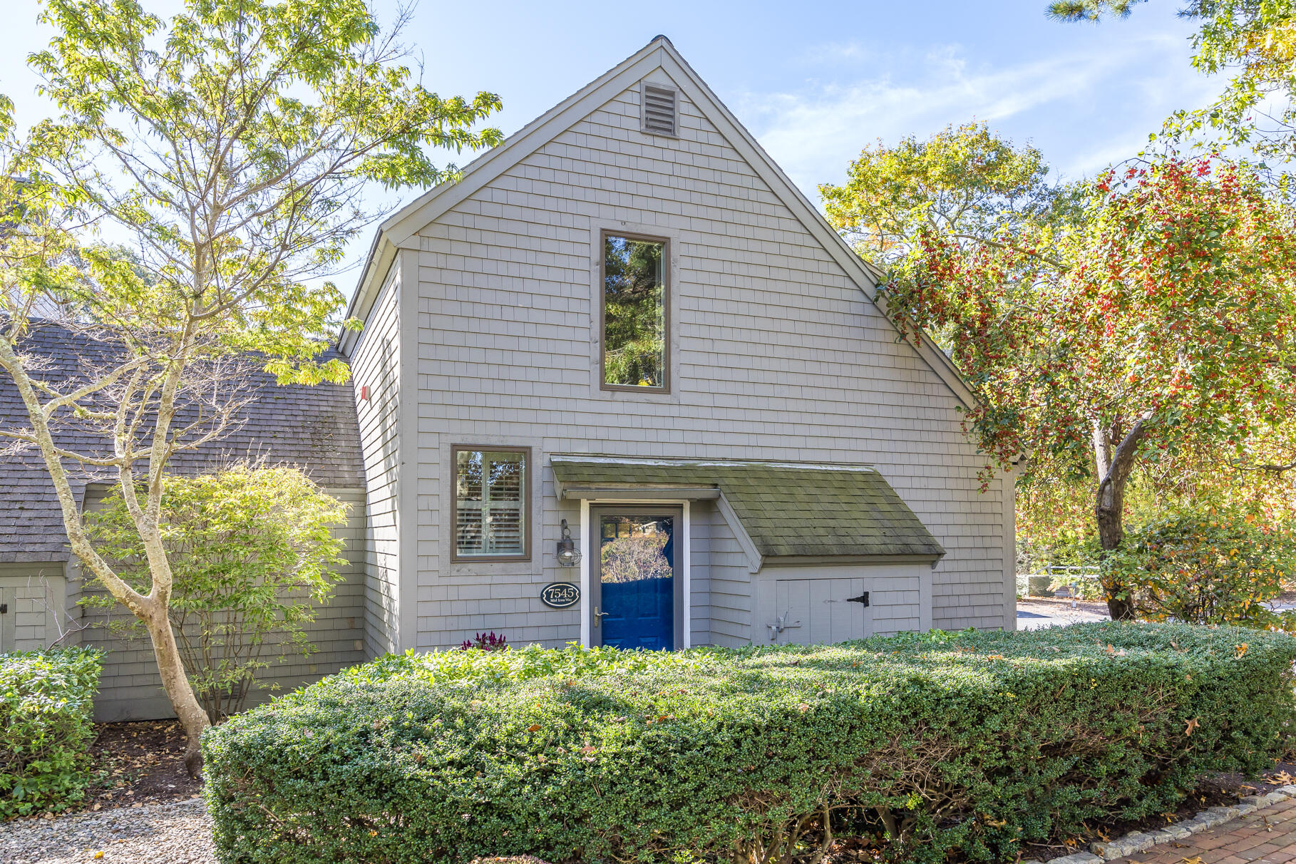 a view of a house with brick walls and a yard with plants