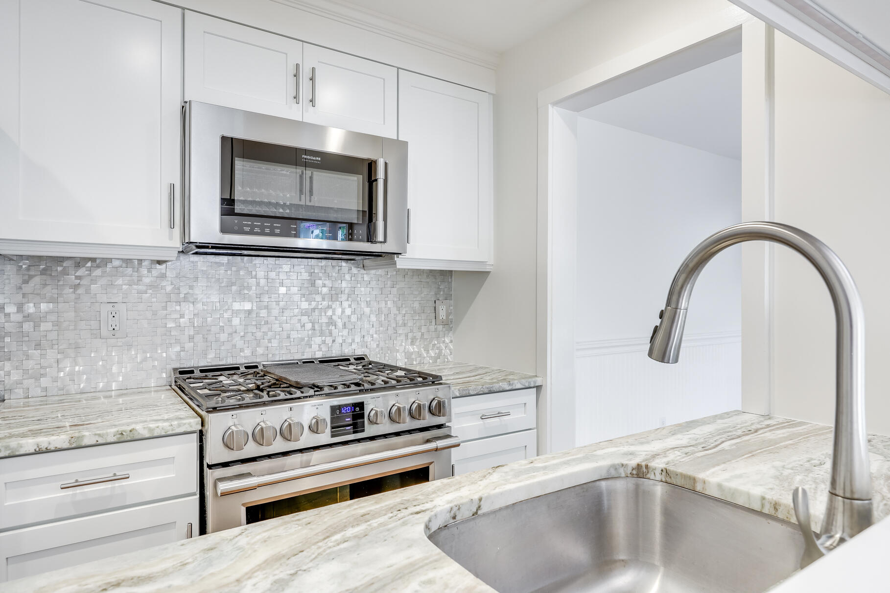 68 Mid-Iron Way, Unit 7545 Mashpee, MA 02649 - Photo 12 of 43 a kitchen with granite countertop a stove and a microwave