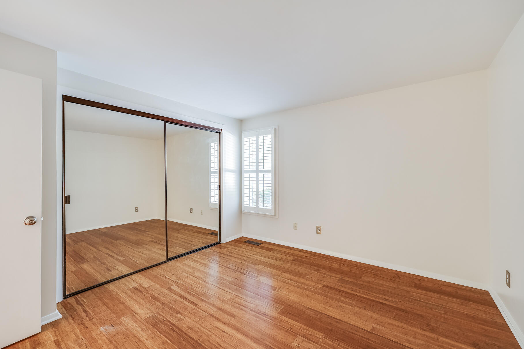 68 Mid-Iron Way, Unit 7545 Mashpee, MA 02649 - Photo 16 of 43 an empty room with wooden floor and door