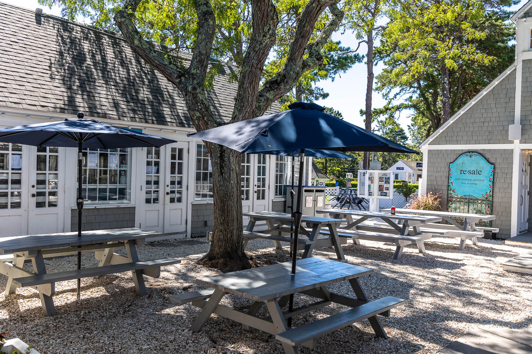 68 Mid-Iron Way, Unit 7545 Mashpee, MA 02649 - Photo 36 of 43 a patio with a table and chairs under an umbrella