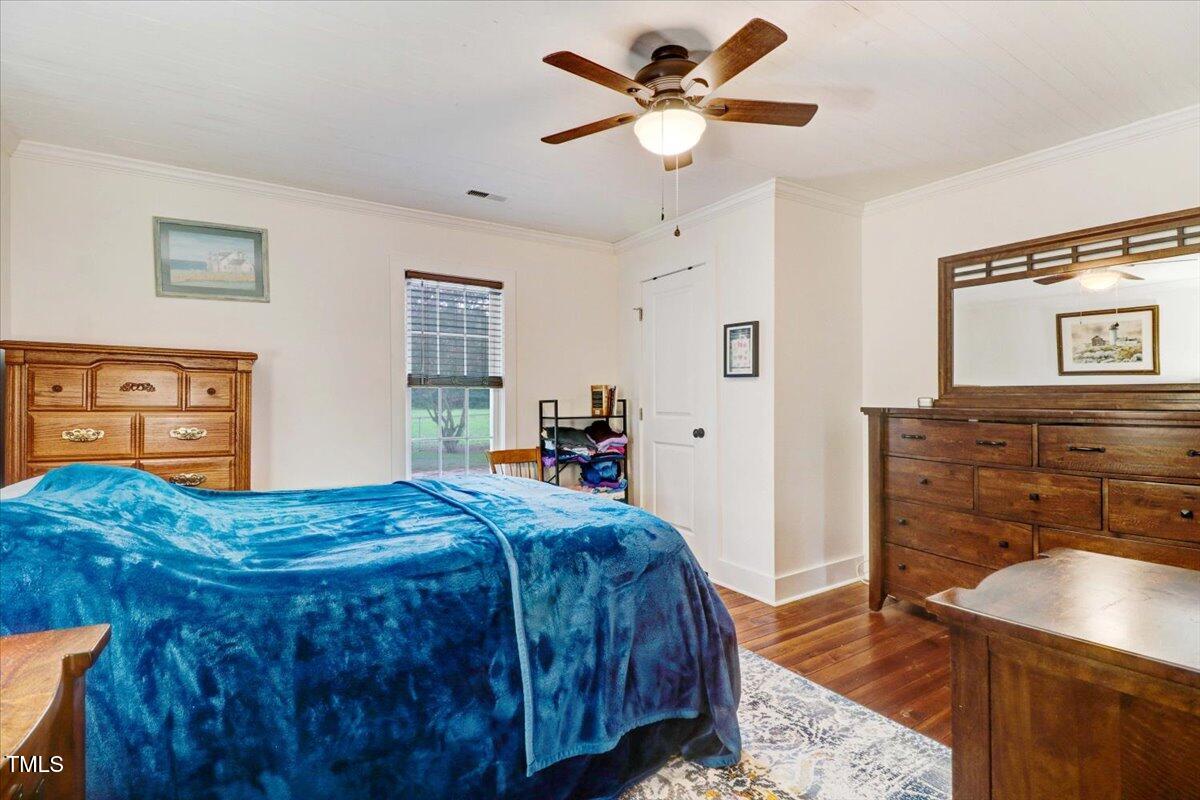 175 Debro Road Kenly, NC 27542 - Photo 20 of 30 a bedroom with a bed a dresser and potted plants
