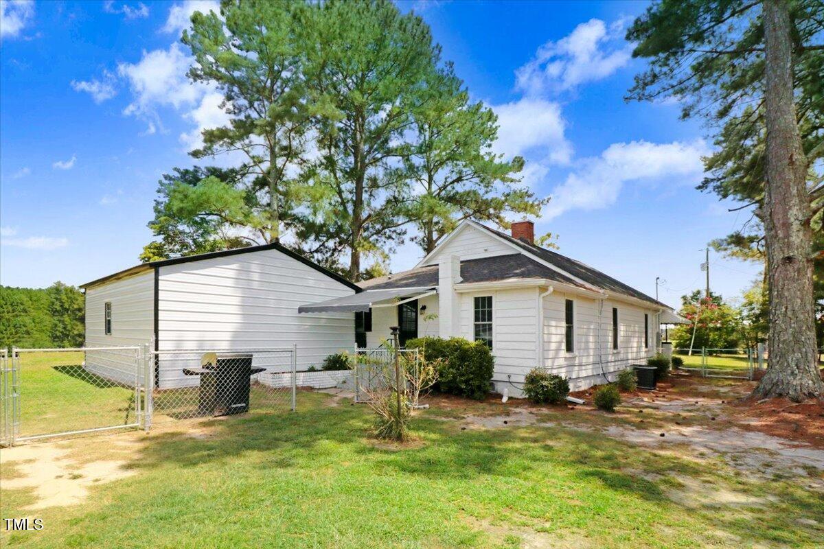 175 Debro Road Kenly, NC 27542 - Photo 27 of 30 a view of a house with a yard chairs and a large tree