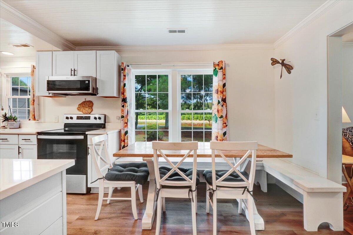 175 Debro Road Kenly, NC 27542 - Photo 10 of 30 a kitchen with stainless steel appliances kitchen island granite countertop a dining table chairs and granite counter tops