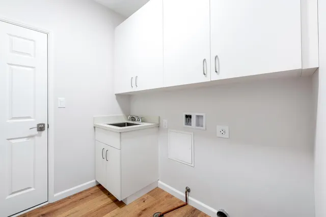 a kitchen with cabinets and wooden floor