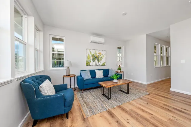 a living room with furniture and wooden floor