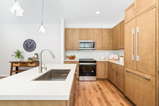 a kitchen with a sink a stove top oven and refrigerator