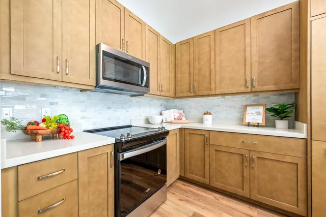 a kitchen with stainless steel appliances granite countertop a sink a stove and cabinets