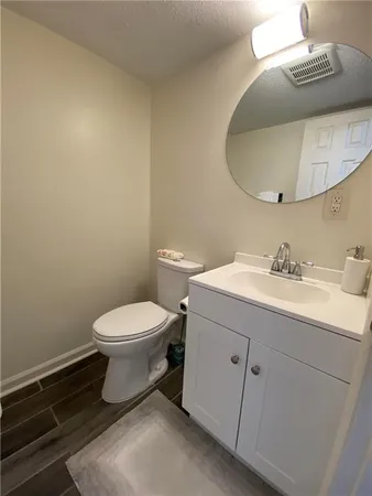 a bathroom with a toilet a sink and mirror