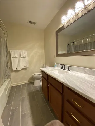a bathroom with a sink mirror and a toilet