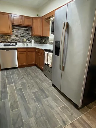 a kitchen with stainless steel appliances granite countertop a refrigerator and a sink