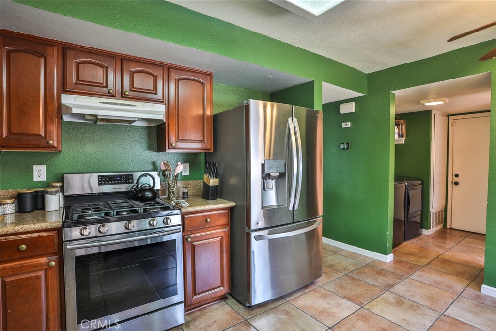 11369 Red Hill Road Moreno Valley, CA 92557 - Photo 12 of 41 a kitchen with stainless steel appliances granite countertop a refrigerator and a stove top oven