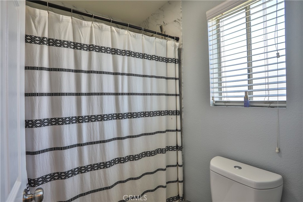 11369 Red Hill Road Moreno Valley, CA 92557 - Photo 25 of 41 a bathroom with a toilet a sink and curtain