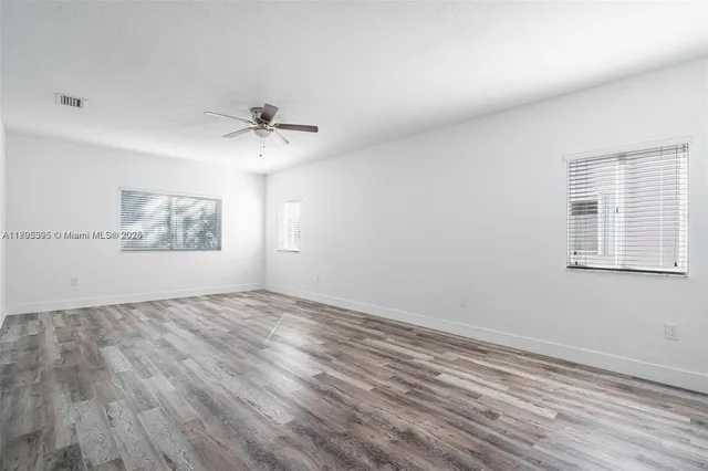 wooden floor in an empty room with a window
