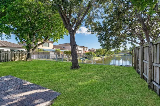 a view of a yard with a house and a large tree