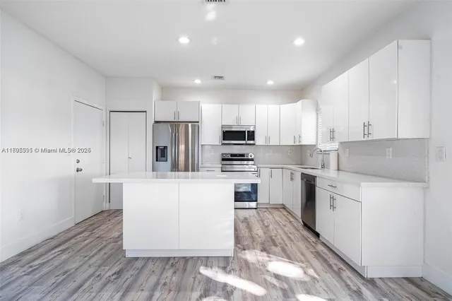 a kitchen with granite countertop white cabinets and white appliances